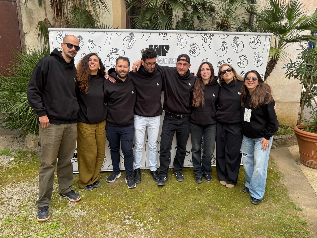 The Italia Nomad Fest team in front of the festival backdrop in Palermo